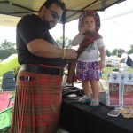 Getting dressed for the occassion! Jay Leask pins the weathered Leask tartan to his daughter Andromache.